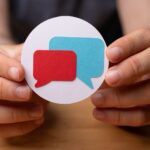 hands holding the talk bubble speech icon